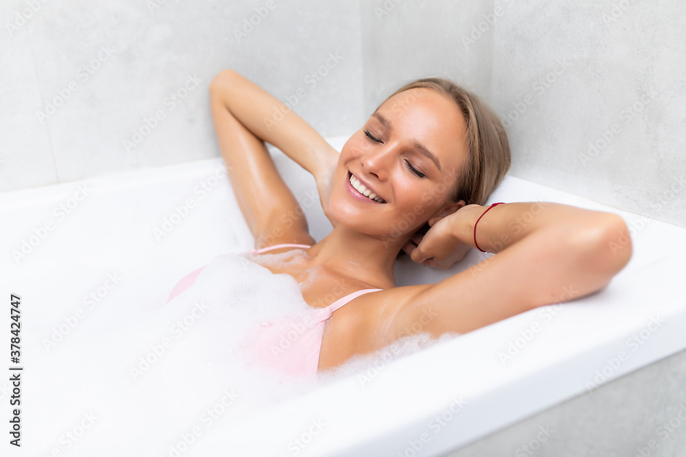 Young woman lies in the bathroom clean skin white foam relaxation Young woman lies in the bathroom clean skin white foam relaxation