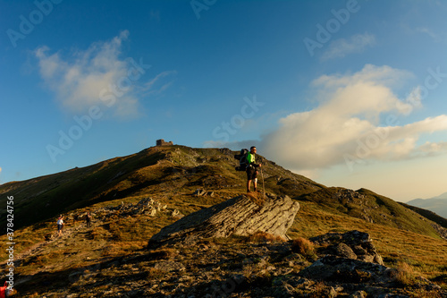 A young man descends from the top of the mountain Pip Ivan, observes the epic landscapes around the mountain, carries a large hiking backpack.