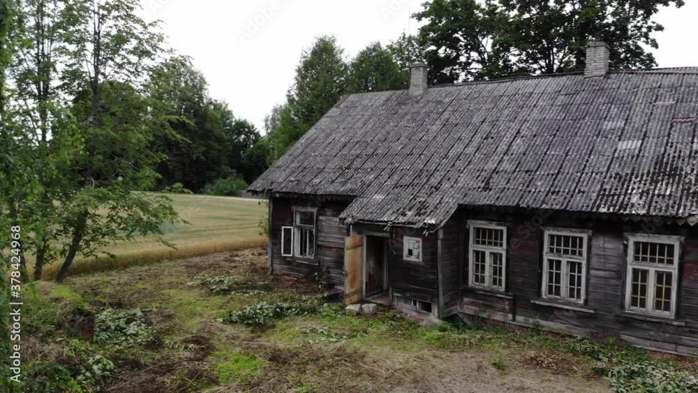 A BROWN / DARK OLD ABANDONED HOUSE WITH BROKEN WINDOWS IN THE COUNTRY SIDE A BROWN / DARK OLD ABANDONED HOUSE WITH BROKEN WINDOWS IN THE COUNTRY SIDE