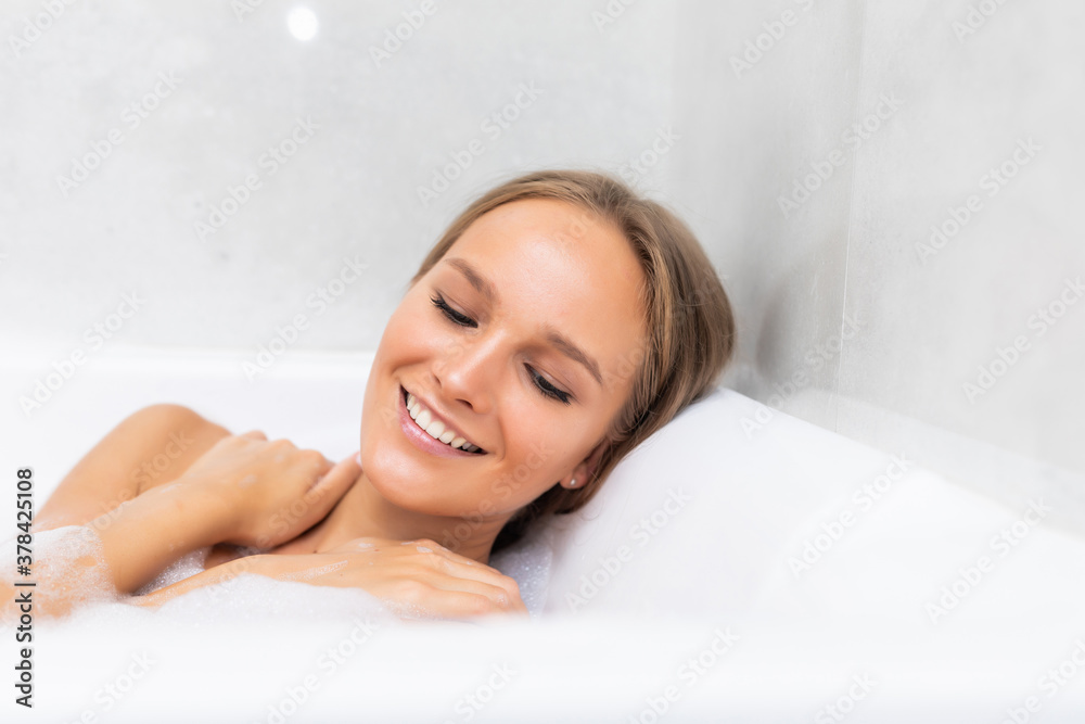 Portrait of smiling young woman laying in bathtub Portrait of smiling young woman laying in bathtub