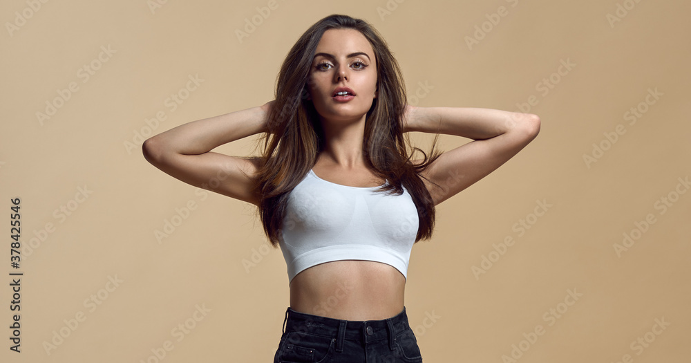 Obraz premium Portrait of Beautiful model posing on beige color background with copy space