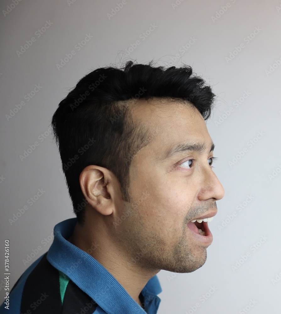 Obraz premium omg. right side face of an asian man with amazed expression looking towards a copy space with white background.