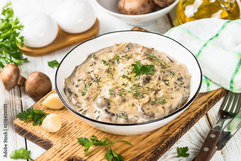 Champignons in cream sauce at white table. Champignons in cream sauce at white table.