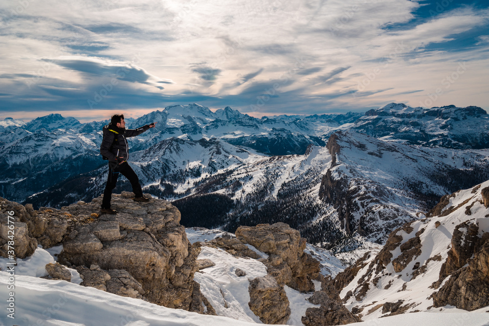 hiking explorer pointing finger looking for direction standing in front of beautiful dolomites landscape in Cortina surroundings, holiday destination. Beautiful place icon, iconic mountain panorama
