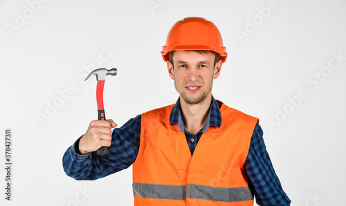young worker is engineer assistant. repairman in uniform. man work with hammer. real construction worker in helmet. carpenter ready to work. building tool repair equipment. He loves his job