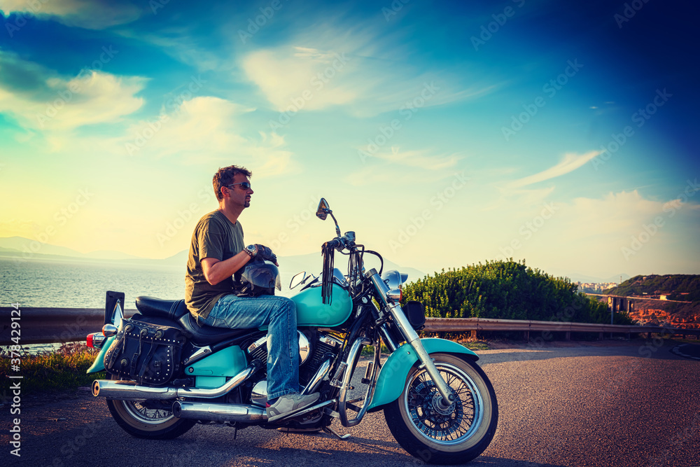 Biker and classic motorcycle parked by the sea Biker and classic motorcycle parked by the sea