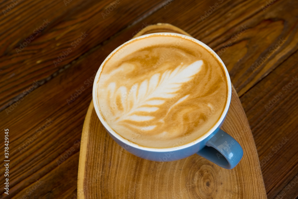 Latte coffee in a cup on a wooden table with copyspace. Latte coffee in a cup on a wooden table with copyspace.