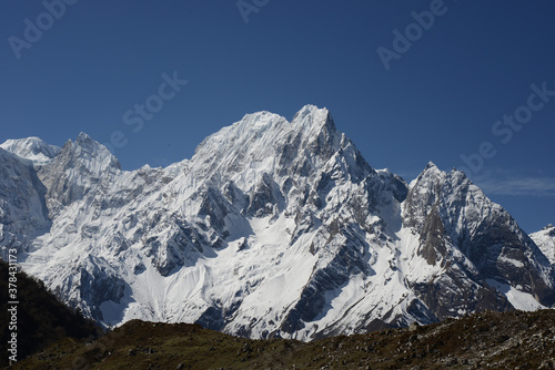 Snow covered peaks in the Himalayas, as see from a high plateau in Nepal, on a bright sunny day with vivid blue skies