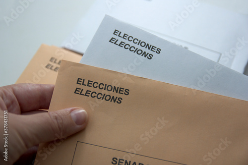 Someone holding a couple of envelopes to vote