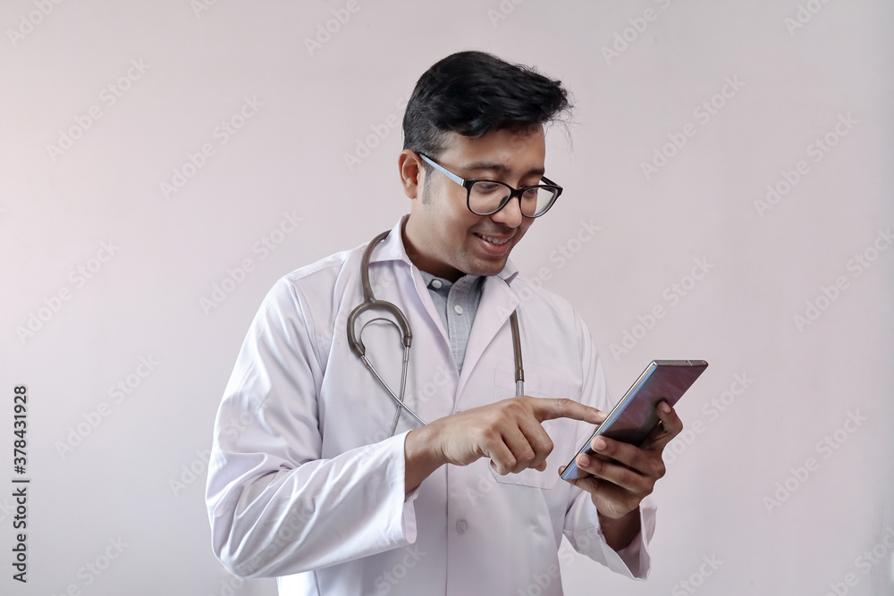 male indian doctor in white coat and stethoscope touching smart phone male indian doctor in white coat and stethoscope touching smart phone