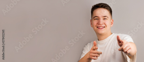 Portrait of happy man with white t-shirt against light gray background. studio shot.