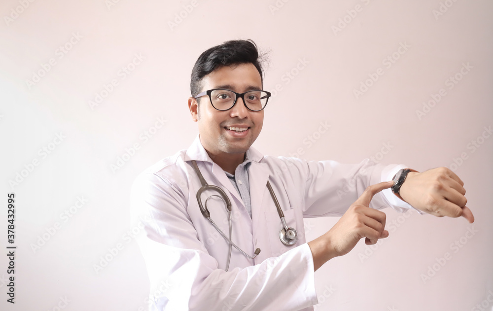 male indian doctor in white coat and stethoscope touch screen and checking notification in smart watch male indian doctor in white coat and stethoscope touch screen and checking notification in smart watch