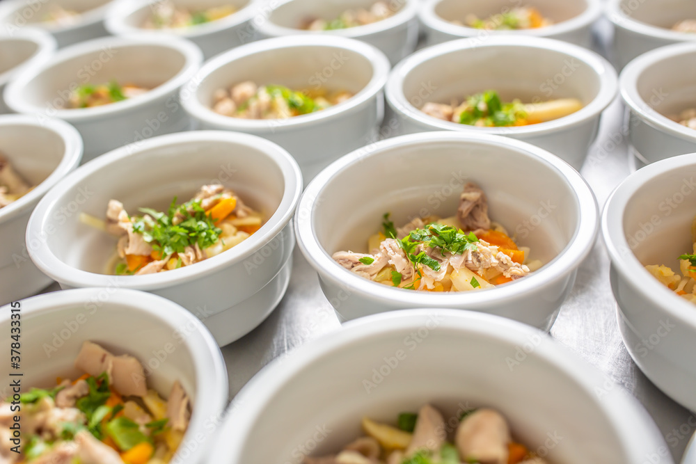Bowls of chicken soup lined up for serving