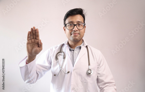 male indian doctor in white coat and stethoscope swearing hippocratic oath