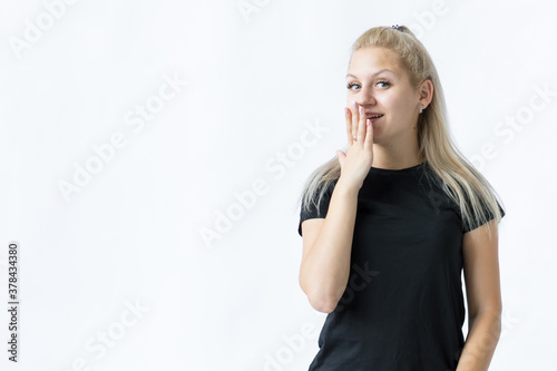 Happy girl covering with hand her mouth, laughing. Photo isolated on white background