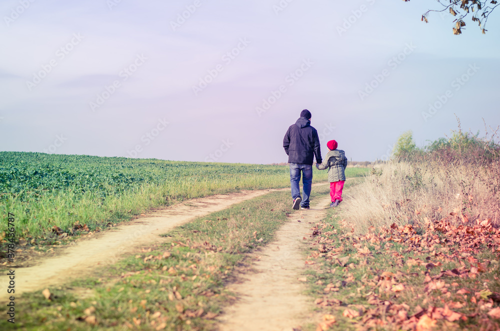 man and girl child walking together in autumnal colorful nature in rural path in sunny day with happy tranquil atmosphere man and girl child walking together in autumnal colorful nature in rural path in sunny day with happy tranquil atmosphere