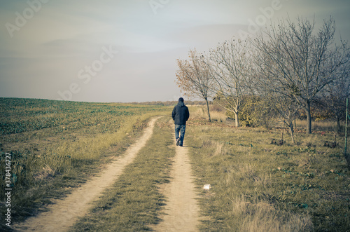one man alone walking away on rural path © katarinagondova