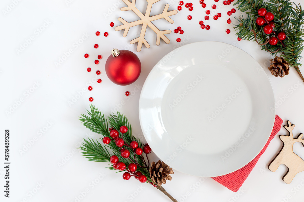 White clean round plate, on a white table with Christmas decorations White clean round plate, on a white table with Christmas decorations