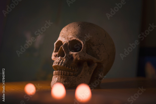 Obraz na płótnie Halloween, skull on the table, candlelight on a dark background, horror, spooky, dark, dark w salonie