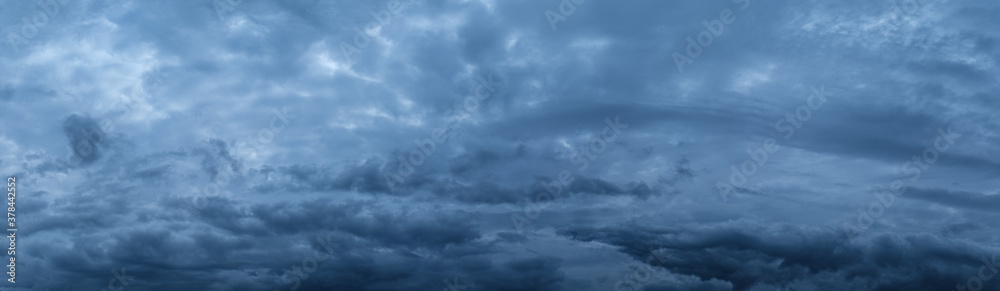 Panorama dark evening sky with blue clouds. Fluffy clouds in the sky. Panorama dark evening sky with blue clouds. Fluffy clouds in the sky.