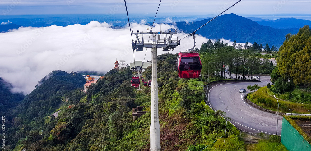 cable car at genting highlands, malaysia in a foggy weather with green grass visible from inside cable car
