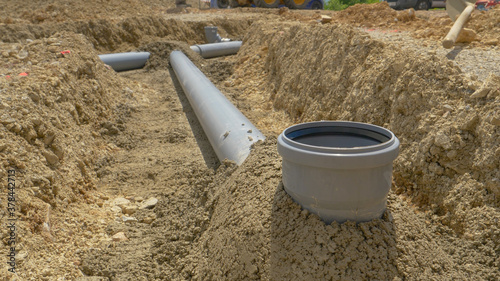 Canvas Print CLOSE UP: Dark grey fresh cement covers pipes of a wastewater drainage system