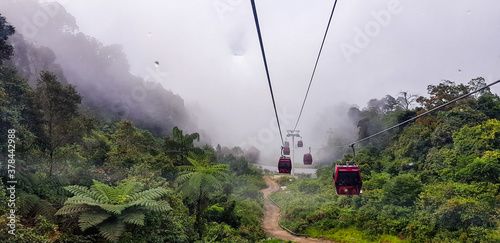 cable car at genting highlands, malaysia in a foggy weather with green grass visible from inside cable car