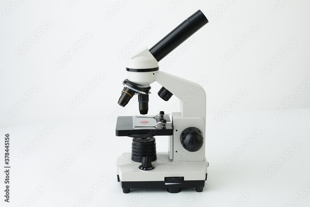 A gray and white microscope is depicted on a white background A gray and white microscope is depicted on a white background