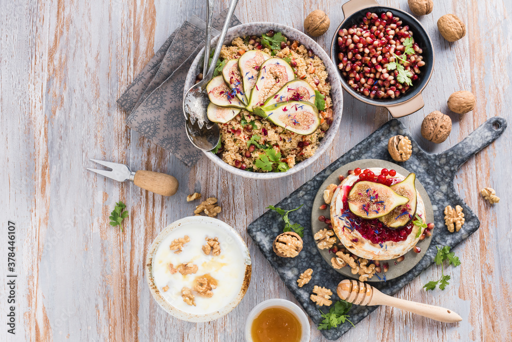 top view of gourmet dish with Figs fruits, nuts, honey, couscous and pomegranate seeds on table