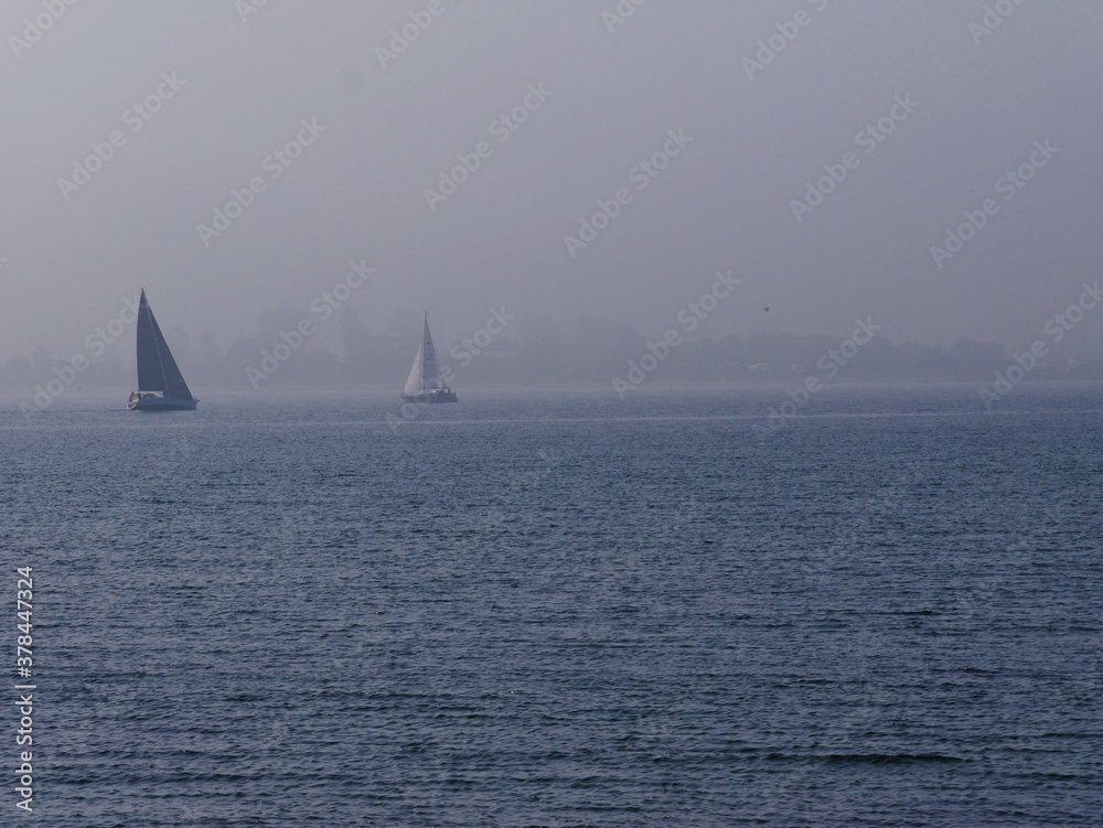Segelboote gleiten über Ostsee im Nebel