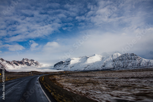 Road leading to Vatnajokull glacier in Iceland in the winter with clouds and blue skies
