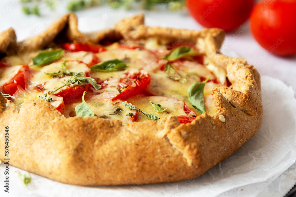 Homemade tomato tart or galette. Whole wheat rustic pie with tomatoes, cheeseand herbs. Healthy food concept. Homemade tomato tart or galette. Whole wheat rustic pie with tomatoes, cheeseand herbs. Healthy food concept.