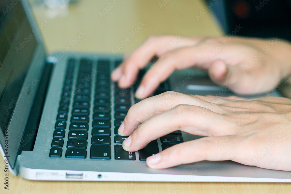 fingers typing on laptop keys, closeup side view fingers typing on laptop keys, closeup side view