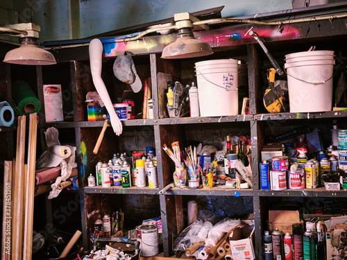 Shelves in an artists studio packed with clutter supplies and material photo