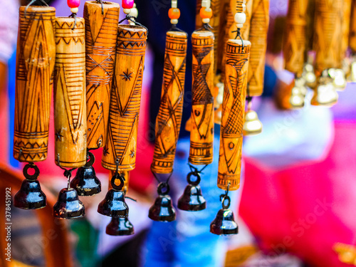 suspended wind chime with hand made wooden carving artwork on bamboo. textured background.tribal artwork. photo