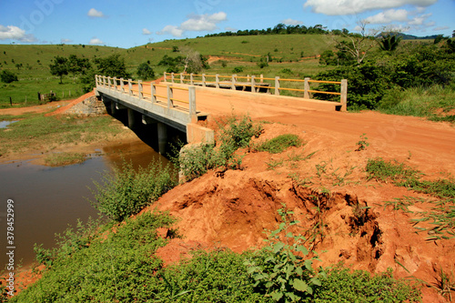 guaratinga, bahia / brazil - may 7, 2009: bus passes on a cement bridge of a dirt road in the rural area of the city of Guaratinga, in southern Bahia. photo