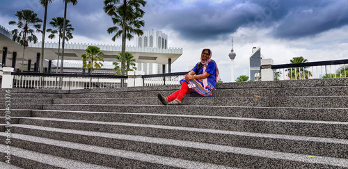 Kuala Lampur, Malaysia - November 2017, Tourist sitting on the stairs in front of Kualalmpur mosque, Malaysia photo