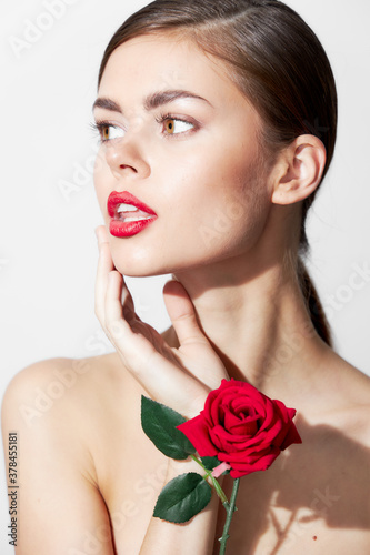 Girl with bare shoulders Model looks towards red lips body care 