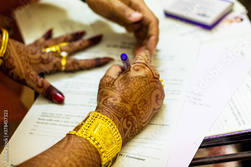 Картината върху платно a newly married indian bengali wife with golden ornament and blacelet signing ma