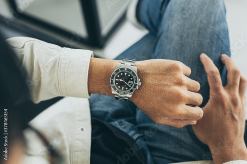 fashionable wearing stylish looking at luxury watch on hand check the time at workplace.concept for managing time organization working,punctuality,appointment photo