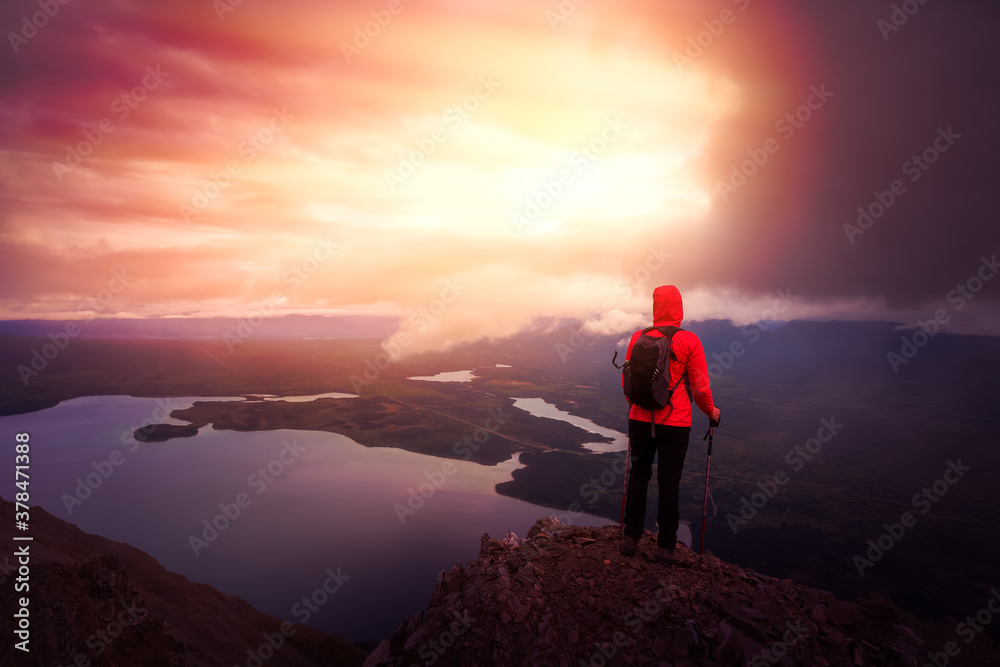Dreamy and Fantasy Render. Adventurous Girl Hiking up a steep rocky mountain during a dark morning sunrise. Taken on a hike to Kings Throne Peak in Kluane National Park, Yukon, Canada.