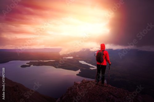 Dreamy and Fantasy Render. Adventurous Girl Hiking up a steep rocky mountain during a dark morning sunrise. Taken on a hike to Kings Throne Peak in Kluane National Park, Yukon, Canada.
