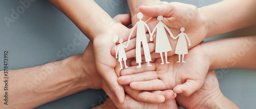 Adult and children hands holding paper family cutout, family home, foster care, homeless charity support concept, family mental health, international day of families