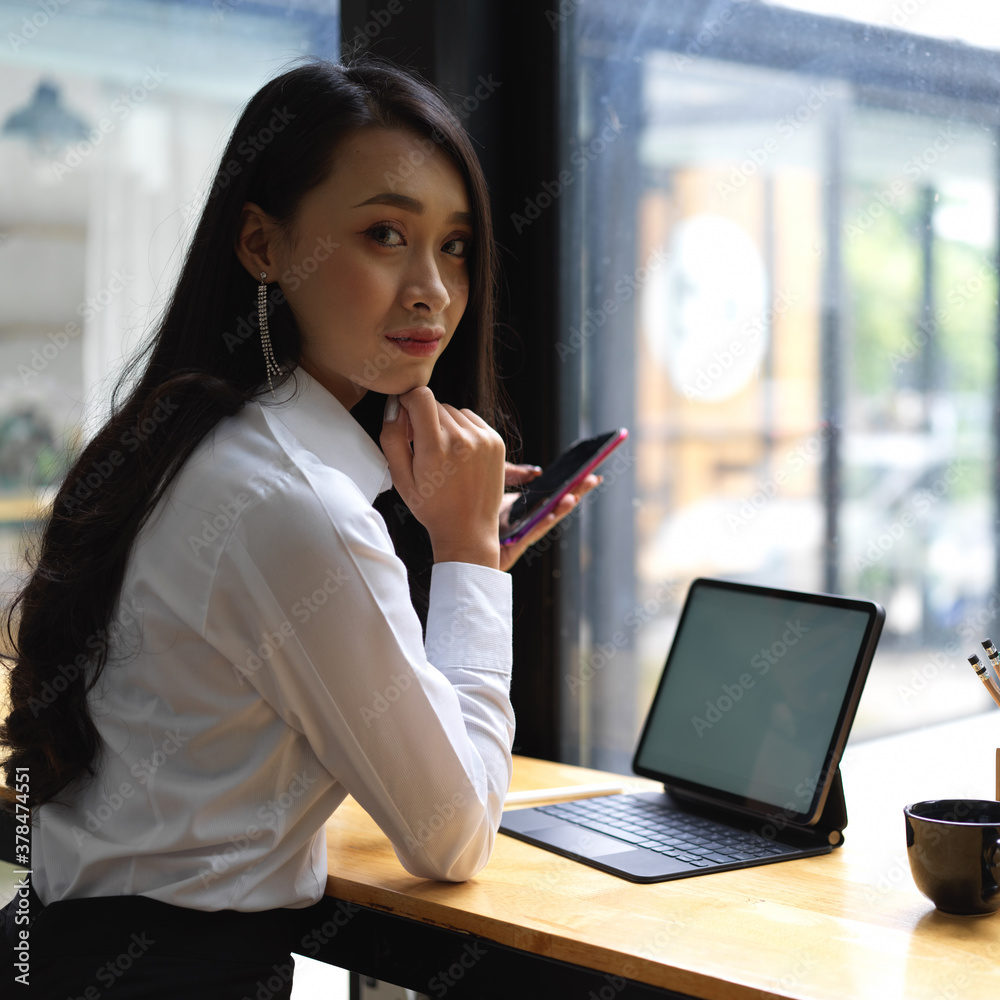 Portrait of female worker looking into camera while working in cafe Portrait of female worker looking into camera while working in cafe