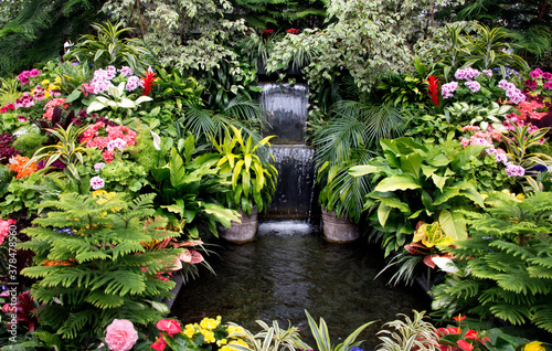 An indoor fountain in the middle of greenery and flowers in Butchart gardens in Victoria, Canada