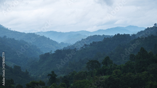 Landscape image of mountains and hills with cloudy sky on rainy day