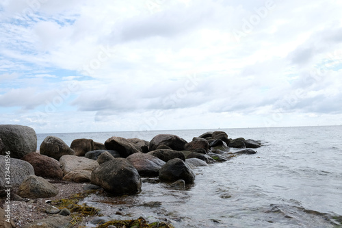 Felsen ragen als Wellenbrecher in die Ostsee