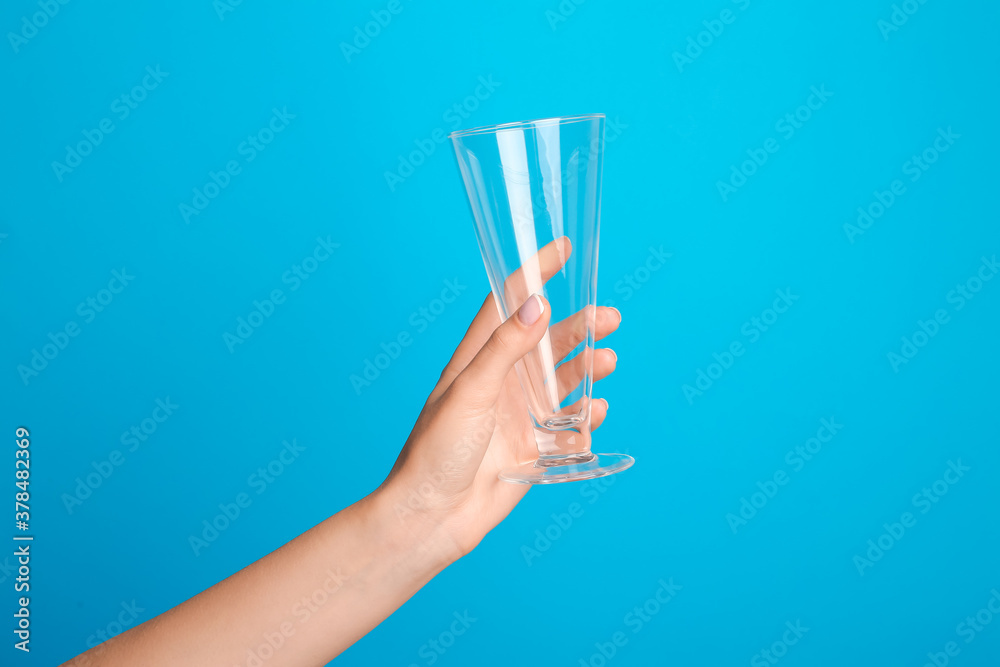 Hand with empty glass on color background Hand with empty glass on color background