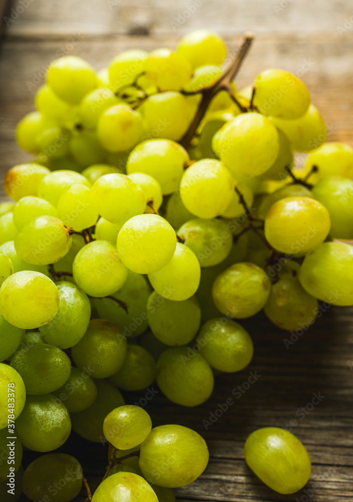 Bunch of ripe green grapes on the rustic wooden table. Selective focus. Bunch of ripe green grapes on the rustic wooden table. Selective focus.