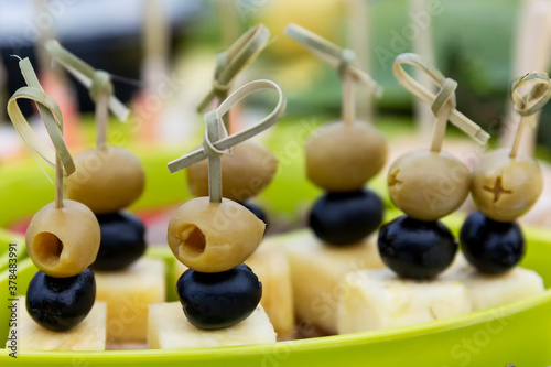 Olives and black olives with cheese on skewers. Festive serving in portions. Close-up.